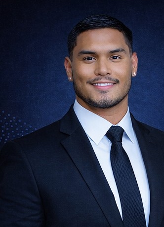 Freddy Narvaez smiling, wearing a navy suit and tie